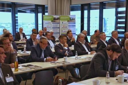 Teilnehmer einer Fachtagung der Beton- und Zementindustrie diskutieren in einem 
